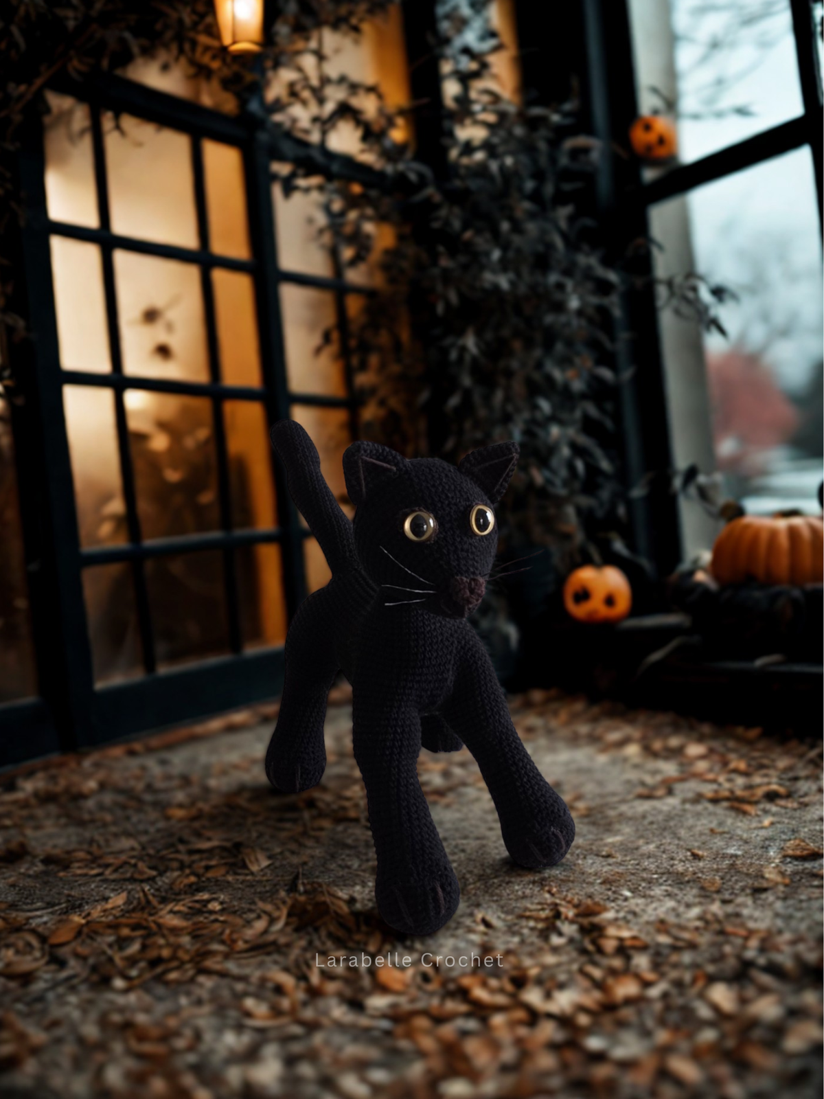 Black cat crochet amigurumi toy in a halloween setting