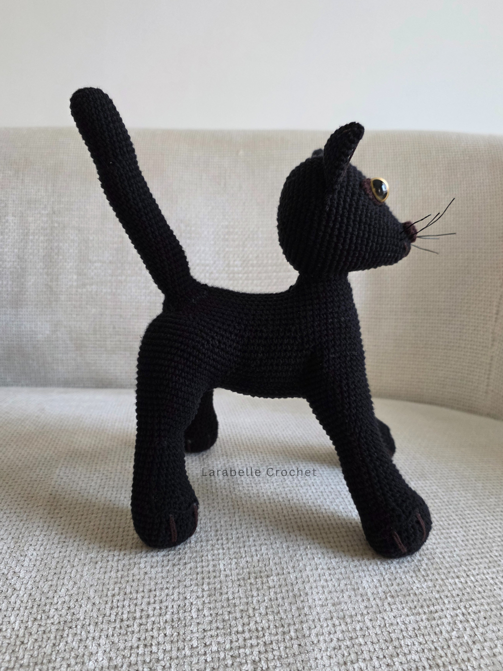 Side view of black cat crochet amigurumi with tail