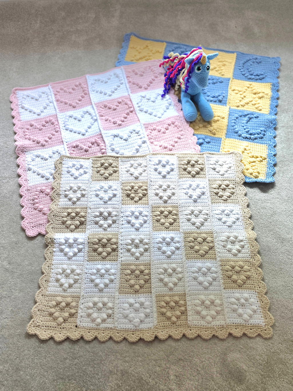 Collection of 3 baby blankets, one with small hearts, one with large hearts and one with starts and moons to suit all baby genders.