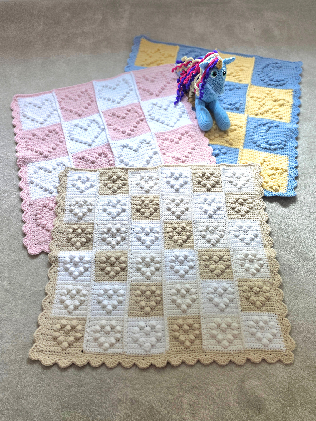 Collection of 3 baby blankets, one with small hearts, one with large hearts and one with starts and moons to suit all baby genders.