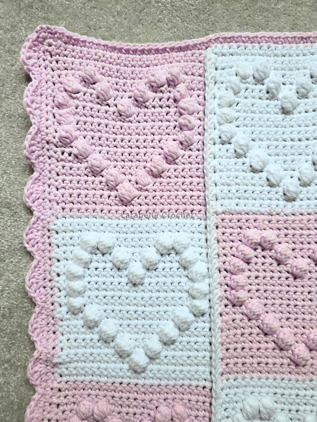 Close up of patchwork heart baby blanket with large hearts using bobble stitch.