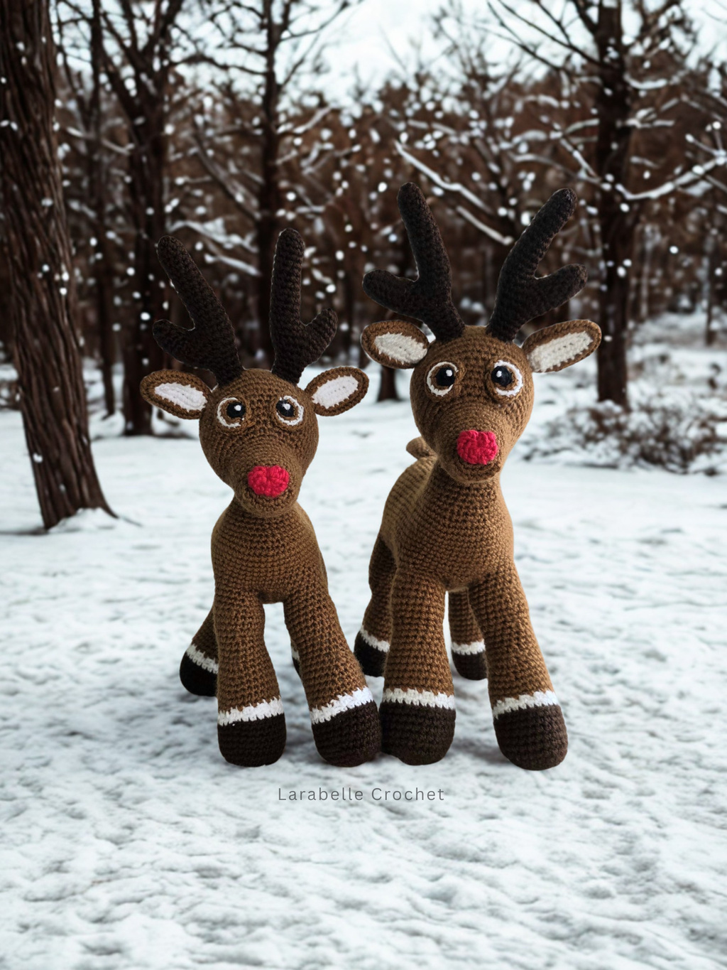 Two crochet reindeer amigurumi toys in a snowy winter setting