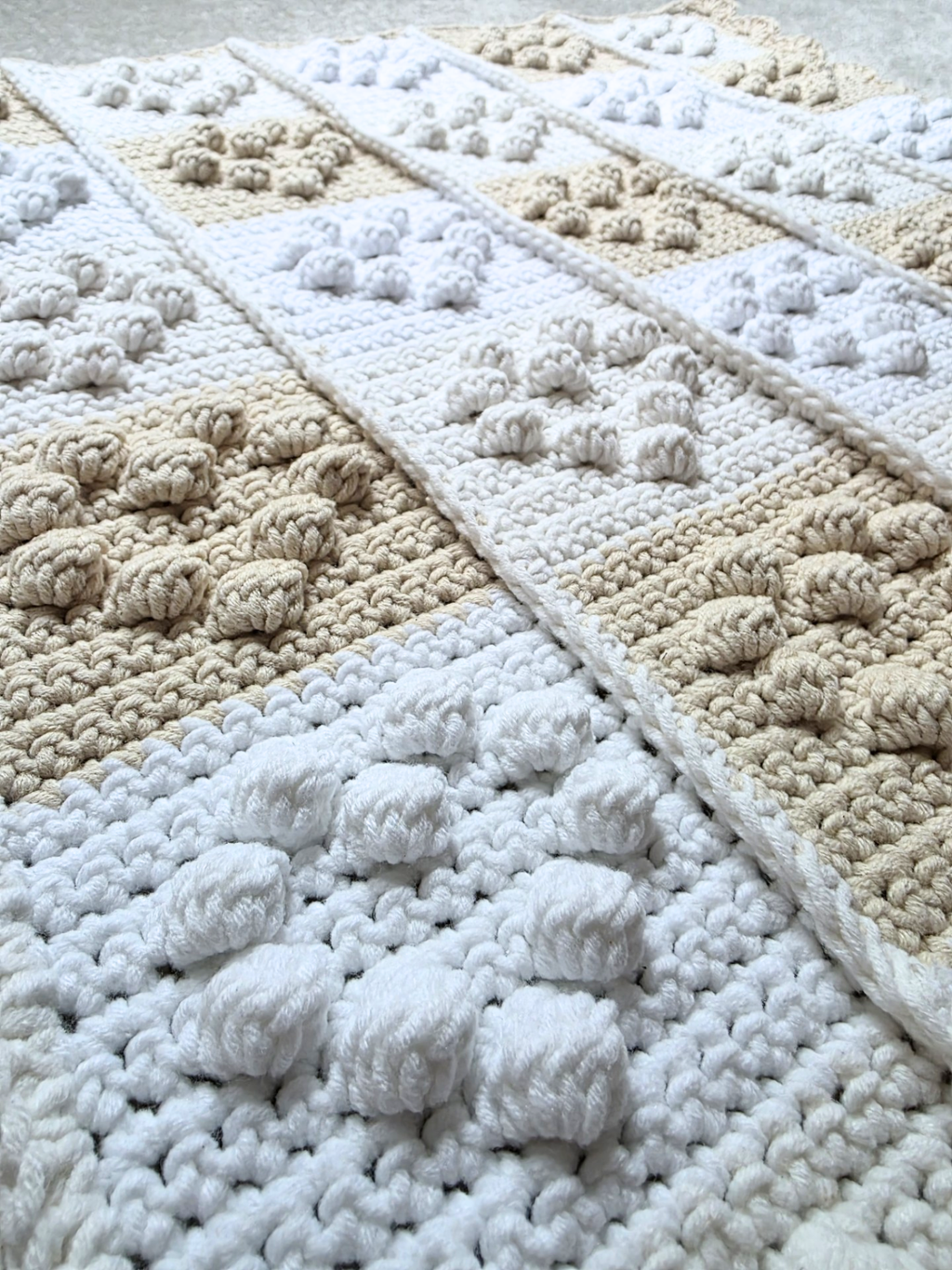 Close up view of crochet baby blanket with small hearts.