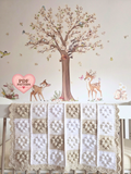 A handmade crochet baby blanket with a patchwork design of cream, beige, and white squares with small hearts.
