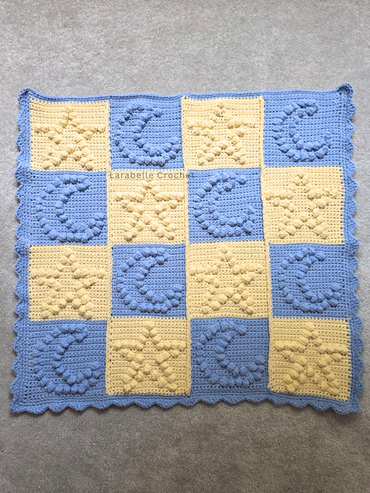 Full view of crochet baby blanket featuring stars and moons in a patchwork grid of 6 x 6.